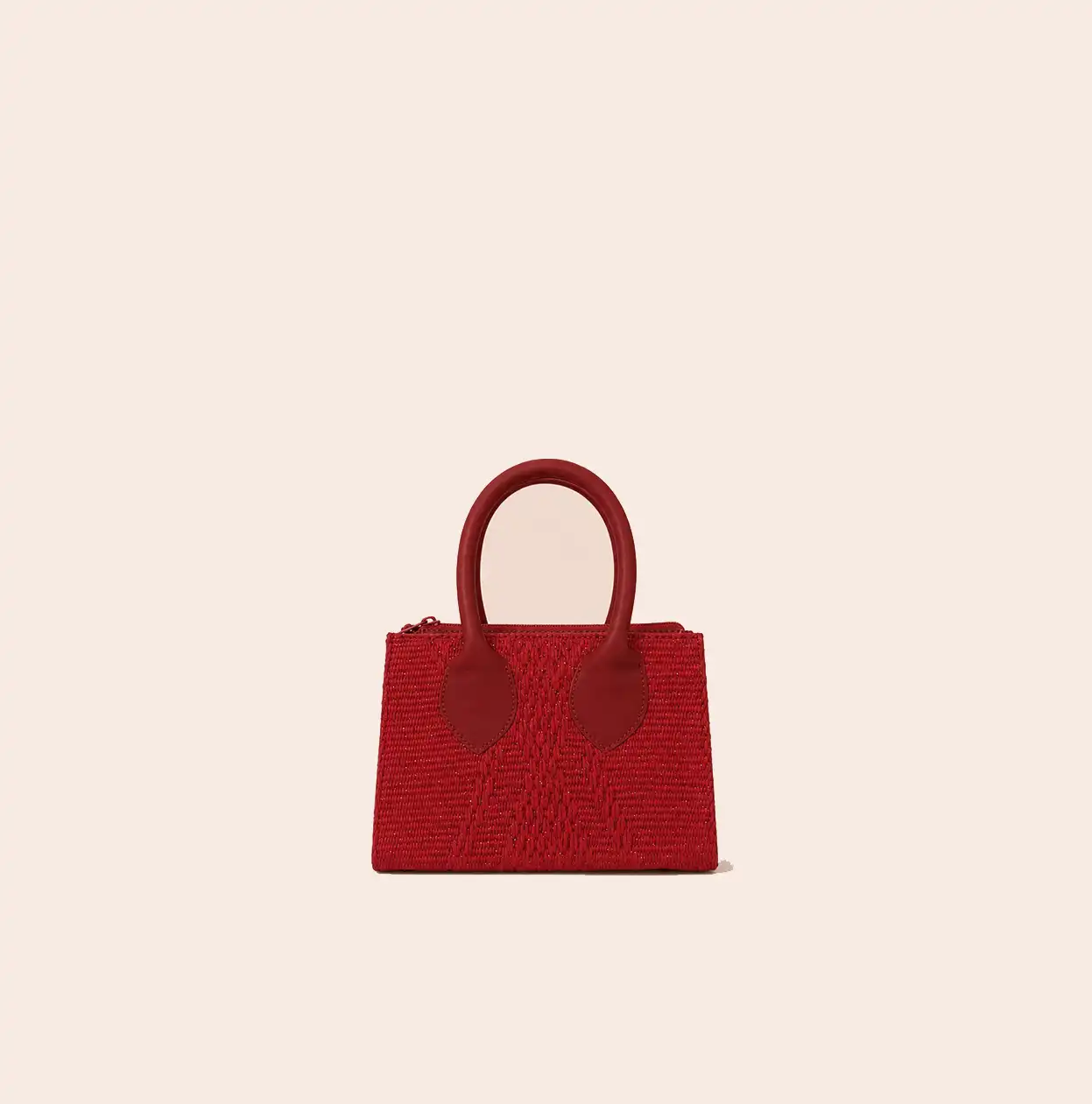 Cartera de mano pequeña Lunaroja en tejido asháninka rojo, con asas cortas y diseño trapezoidal.